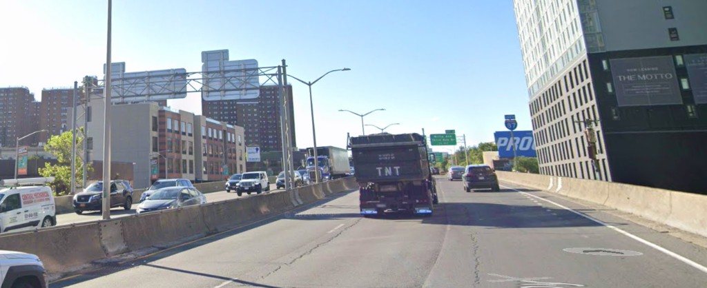 I-87 traffic looking toward The Motto building and the Willis Ave / Third Ave Bridge signs.